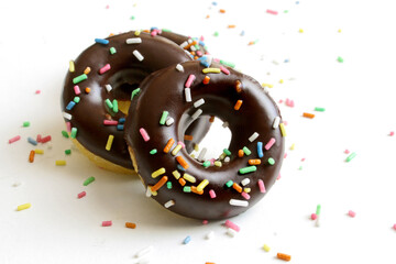 Chocolate glazed mini donuts on a white background
