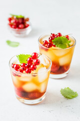Red currants, strawberry summer refreshing cocktails, berry iced tea in glasses. Space fot text.