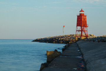 Fototapeta na wymiar A Red Breakwater Lighthouse Along Lake Michigan