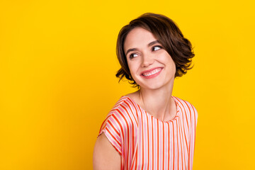 Photo of pretty young happy dreamy woman look empty space good mood isolated on yellow color background