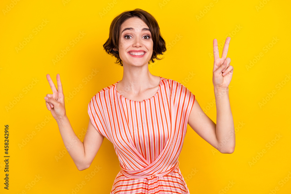 Poster portrait of attractive cheerful girlish girl showing double v-sign good mood isolated over bright ye