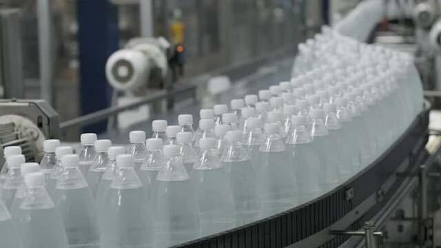 Conveyor belt with bottles of drinking water at a modern beverage plant