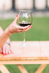 Woman holding a glass with red wine in her hand
