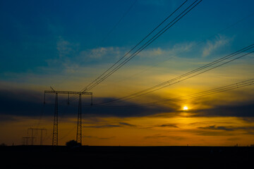 Electric high voltage pole at sunset background