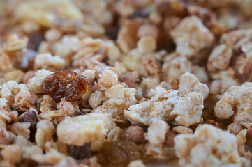 Close-up of dry muesli with nuts and raisins from above.