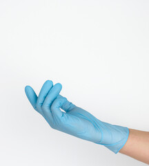 Doctor's hand in a blue medical glove holds an object on a white background. Copy space, hold any object