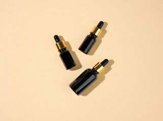 glass cosmetic brown bottles with a pipette on a beige background. Cosmetics SPA branding mockup, top view