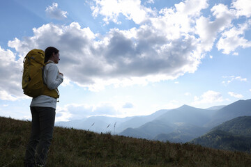 Fototapeta na wymiar Tourist with backpack enjoying mountain landscape. Space for text