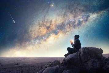 person on the rock outdoors meditating or praying at night under the Milky Way and shooting star	
 - obrazy, fototapety, plakaty