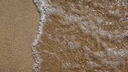 Soft sea wave on clean sandy beach. Abstract sand of beach and soft wave background