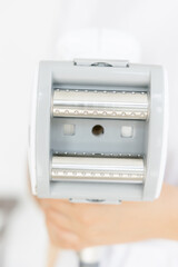 Fototapeta premium The handle of the massage device. body and face massage. beauty salon. Manipulator for lpg massage on the hands of a cosmetologist. Close-up view.