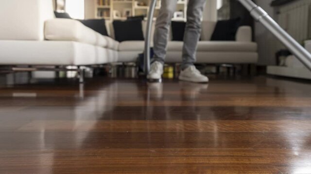 Man who cleans the floor of the house with vacuum cleaner. Time lapse.