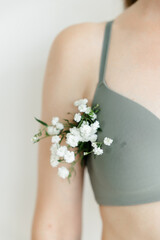 a part of the girl's body. white flowers stick out of the armpit. the concept of cosmetology and...