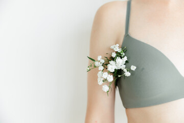 a part of the girl's body. white flowers stick out of the armpit. the concept of cosmetology and...