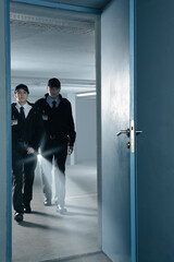 Fototapeta premium Security guards with flashlight in empty parking garage