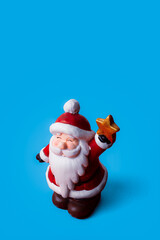 Christmas ornament of Santa Claus on blue background with copy space.