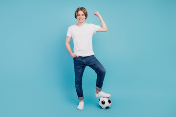 Photo of positive man football winner holding soccer ball isolated blue background