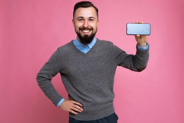 Smiling happy handsome happy cool young brunette unshaven man with beardwearing stylish grey...