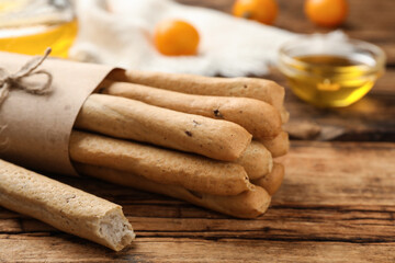 Delicious grissini sticks on wooden table, closeup