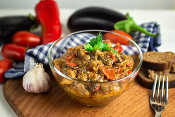 popular vegetable dish of world cuisine in a glass bowl close-up - Ajapsandali, Pinjur, stewed vegetables, eggplant caviar. ngredients: eggplants, tomatoes, bell peppers, garlic, spices. keto diet 