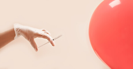 Concept with syringe and hand in gloves injecting a balloon. Spa, medicine, healthcare, treatment,...