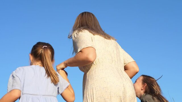 Happy family enjoying their summer vacation, hugging nd jumping, together. Slow motion. Family, vacation and travel concept.