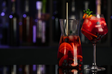 Delicious sangria cocktail on black table in bar. Space for text