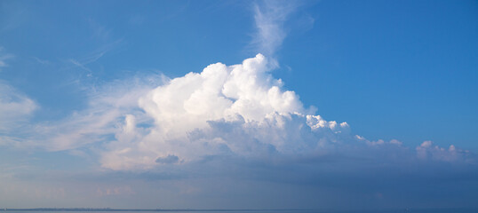 Airy light fluffy clouds over the strip of the sea. Skyline panorama. Meteorological phenomenon