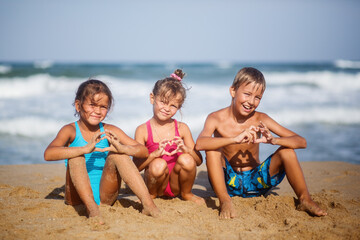 Group of happy children at sea beach on sunny day. Summer camp