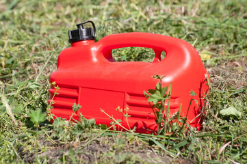 a red plastic gas canister among the green grass