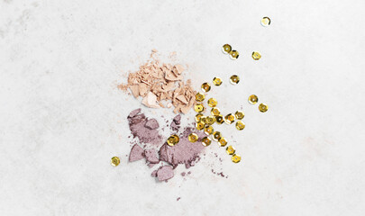 still life composition with crushed eye shadows with a sparkles on light  background. Concept of autumn make up. 