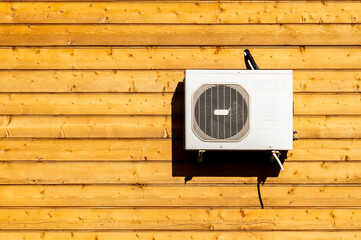 air conditioning on the wall of a log house