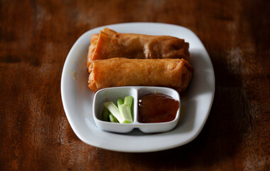 Lumpia on a white plate with chili sauce and chili sauce. Lumpia is a typical food from Indonesia.