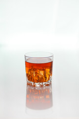 Glass of whiskey with ice on white background 
