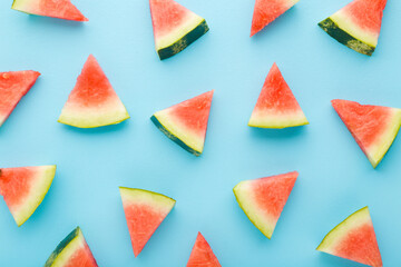 Beautiful fresh red pieces of watermelon on light blue table background. Pastel color. Closeup. Sweet food pattern. Top down view.