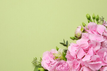 Beautiful composition with hortensia flowers on green background, flat lay. Space for text