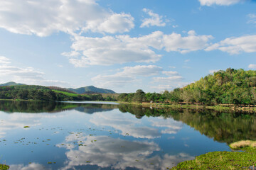 A reservoir that is surrounded by nature and has a beautiful view of the sky, and there are also sky shadows reflected in the water.