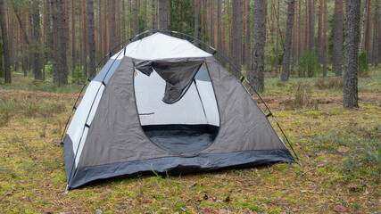 blue tourist tent without awning, stands in the forest