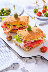 Ciabatta sandwich with guacamole, prosciutto, lettuce and tomato