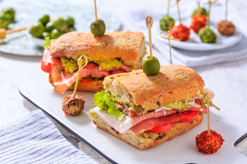 Ciabatta sandwich with guacamole, prosciutto, lettuce and tomato