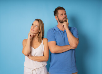 Portrait of pensive young couple in casual wear standing together with crossed hands.