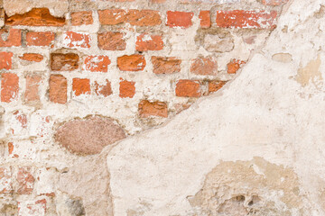 Grunge background. Red brick wall with stone and bright abandoned plaster texture