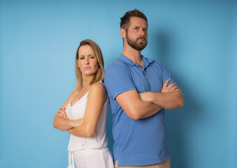 Portrait of upset young couple in casual wear standing together with crossed hands.