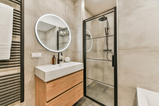 Shower cabin and sink with bathtub in bathroom