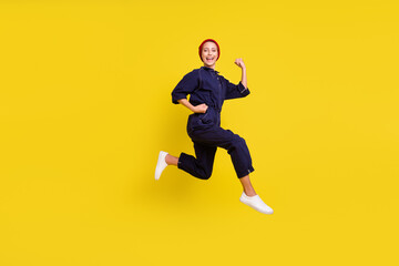 Fototapeta na wymiar Full size photo of young beautiful smiling woman running fast speed in air wear red beanie isolated on yellow color background