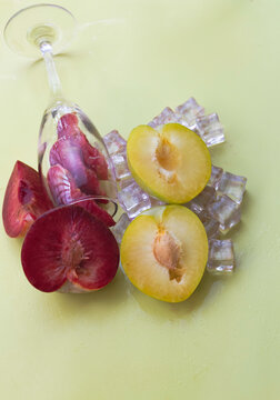 Cutted of Plumcot put in glass wine beside yellow Plum friut on icecube,