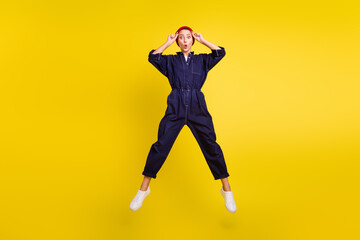 Full length body size view of attractive amazed funky girl jumping having fun isolated over bright yellow color background