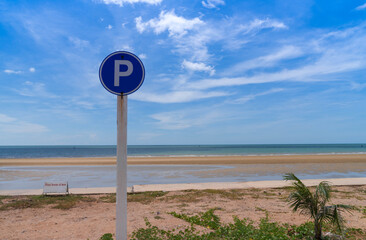 P sign in circle traffic symbol for parking near beach view with bright cloudy blue sky. sunny day. summer vacation.