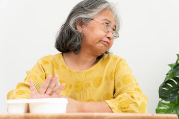 Unhappy Asian senior woman anorexia and say no to ready meals, Elderly home alone and bored food...
