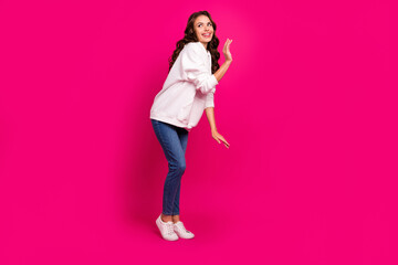 Photo of pretty playful coquette lady look empty space wear white hoodie jeans shoes isolated pink color background